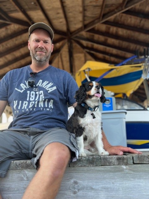 andy sitting on a wooden dock